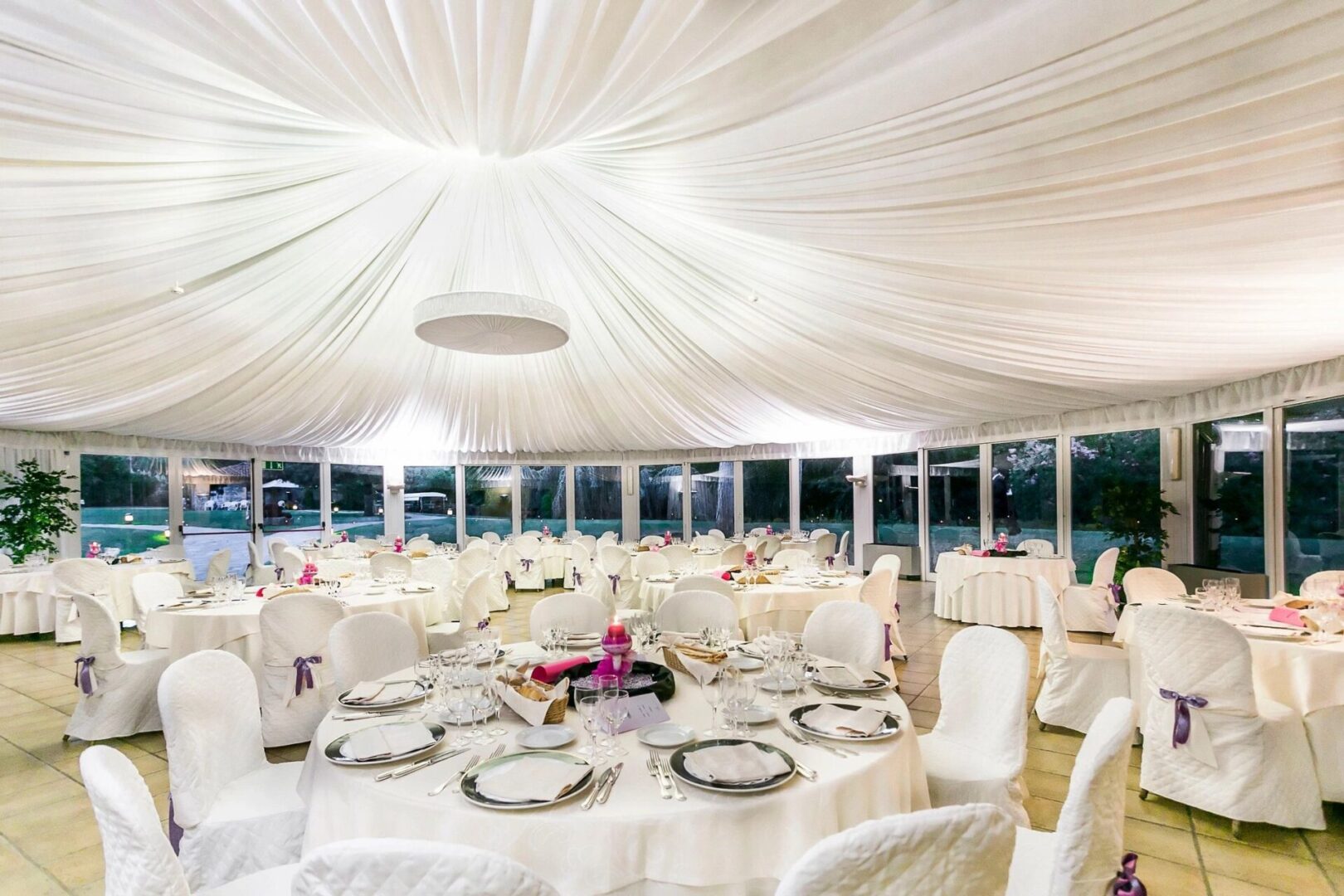 A large white tent with many tables and chairs.