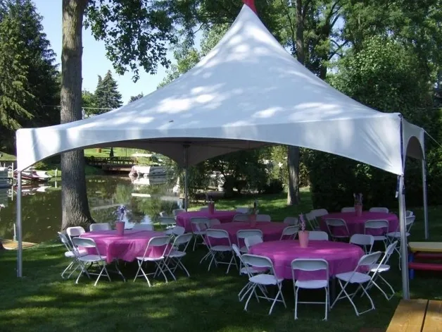 A tent with tables and chairs set up in the grass.