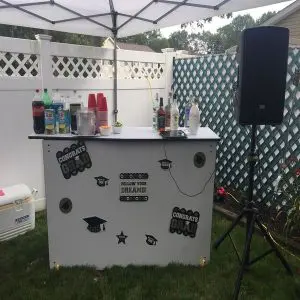 A white bar with speakers and a table