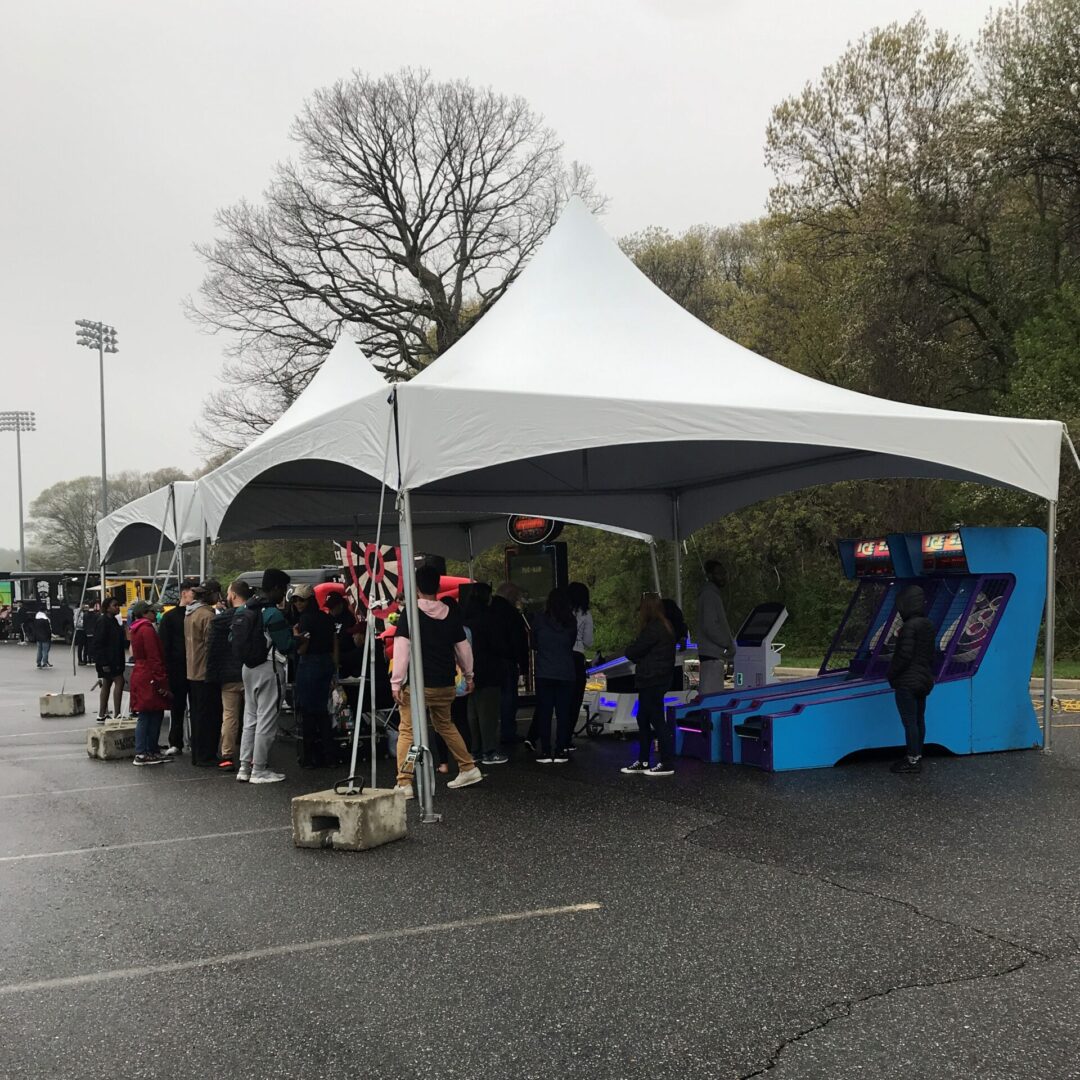 A group of people standing under a tent.